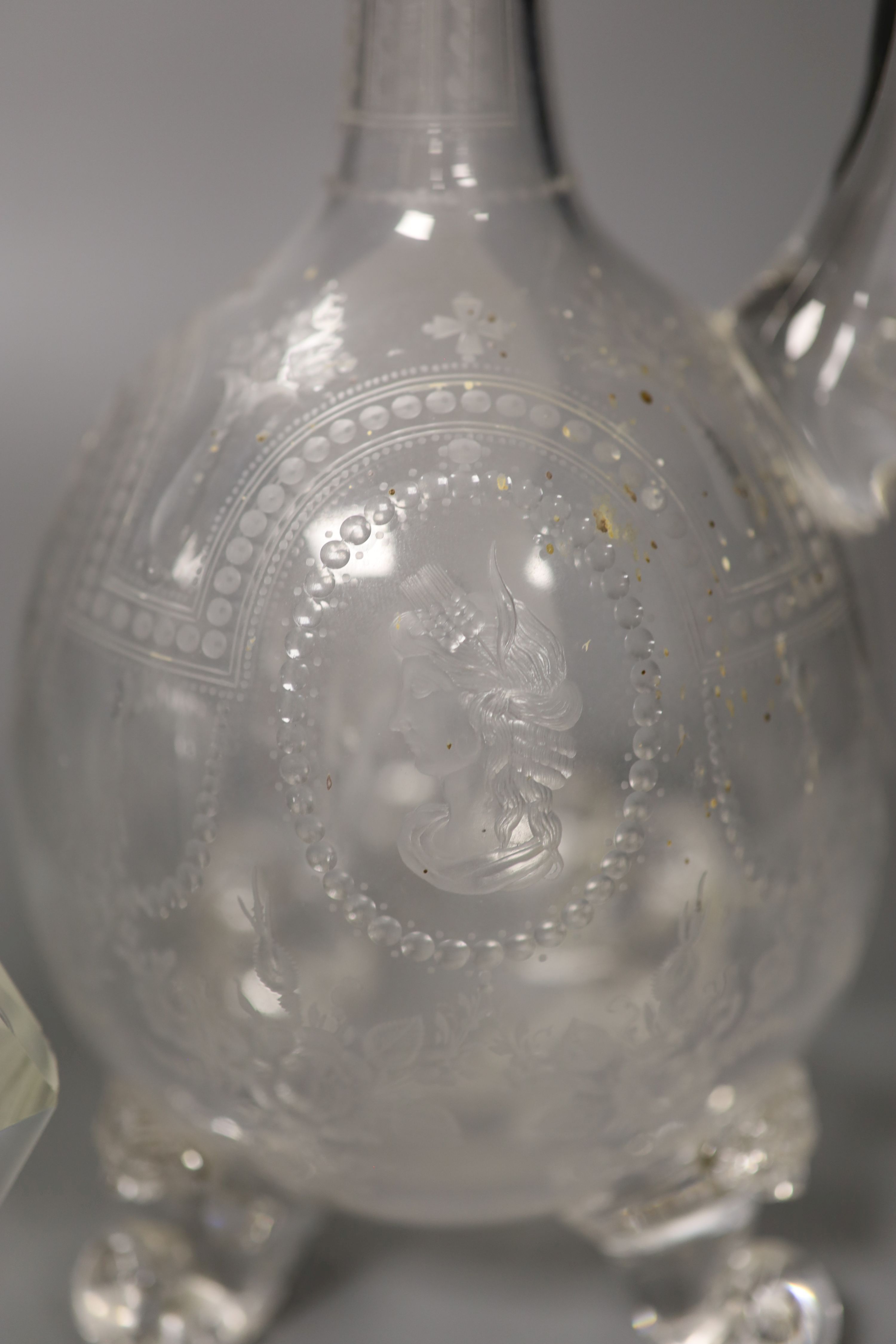 A George V silver collared decanter, a facet cut glass decanter and a wheel engraved glass claret jug with associated stopper, tallest